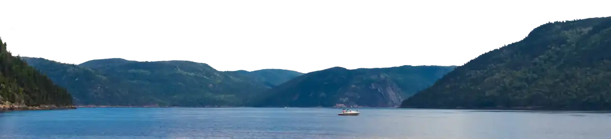 A boat on the water surrounded by mountains