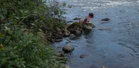 Un membre de RivTemp installant une sonde de température dans une rivière